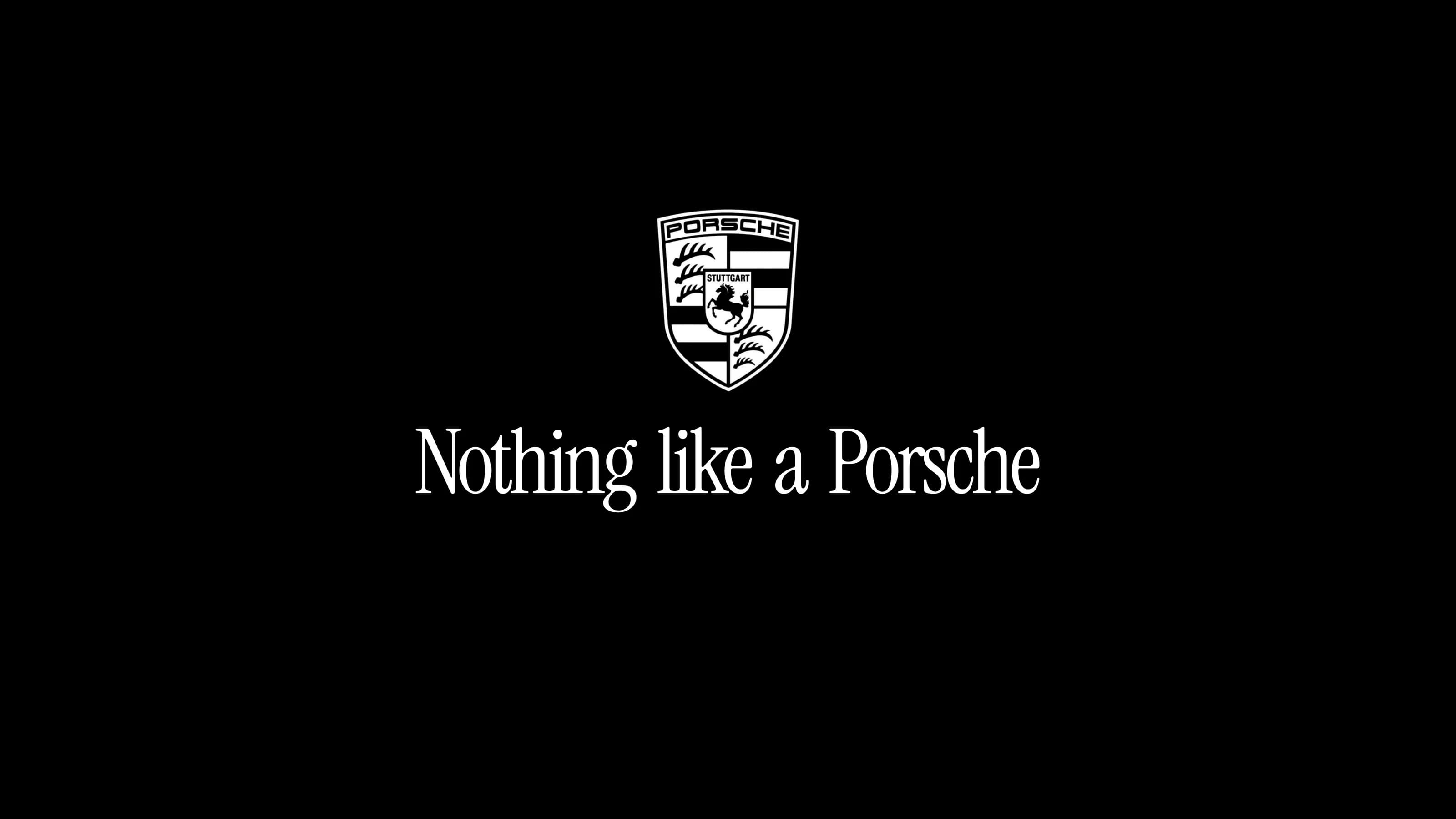 The Porsche crest in white above the line Nothing like a Porsche, on black.